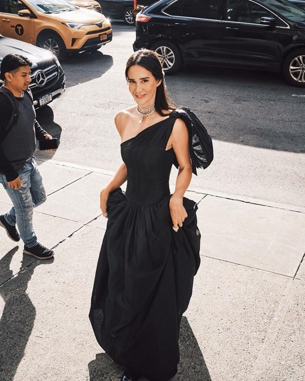 Mulher andando na rua com vestido preto de gala - Metrópoles